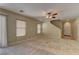 Cozy living room with neutral carpet, a ceiling fan, and natural light, with open floor plan at 12045 Yarrow Ridge Ct, Las Vegas, NV 89183