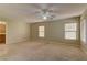 Spacious living room with ceiling fan and multiple windows, offering ample natural light and comfort at 12045 Yarrow Ridge Ct, Las Vegas, NV 89183