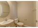 Well-lit powder room featuring a round mirror, pedestal sink, and neutral color palette for a clean and inviting space at 12045 Yarrow Ridge Ct, Las Vegas, NV 89183