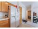 Efficient kitchen layout with white refrigerator, wood cabinets, and a convenient pantry at 1312 Pacific Terrace Dr, Las Vegas, NV 89128