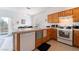 Bright kitchen with white appliances, wood cabinets, and a breakfast bar at 1312 Pacific Terrace Dr, Las Vegas, NV 89128
