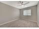 Well-lit carpeted bedroom featuring a window and a ceiling fan at 2061 Smoketree Village Cir, Henderson, NV 89012