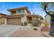 Charming exterior view of a beige two-story home with a well-maintained front yard at 2061 Smoketree Village Cir, Henderson, NV 89012