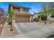 Two-story home with a front yard, two car garage, and desert landscaping at 2061 Smoketree Village Cir, Henderson, NV 89012