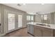 Kitchen with stainless steel sink and appliances, stone countertops, and French doors to back at 2061 Smoketree Village Cir, Henderson, NV 89012
