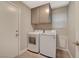 Laundry room with a washer, dryer, and wall-mounted cabinets at 2061 Smoketree Village Cir, Henderson, NV 89012
