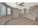 Open-concept living room with wood floors, ceiling fan, and staircase at 2061 Smoketree Village Cir, Henderson, NV 89012