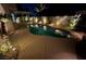 A beautiful, illuminated backyard pool at night, creating a tranquil and inviting outdoor oasis at 2061 Smoketree Village Cir, Henderson, NV 89012