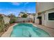 A refreshing backyard pool with a curved design, surrounded by a well-maintained patio and privacy fence at 2061 Smoketree Village Cir, Henderson, NV 89012