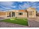 Well-maintained backyard featuring a neat lawn, desert landscaping, and a covered patio at 2345 Hot Brook Point St, Las Vegas, NV 89134