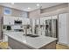 Modern kitchen featuring white cabinets, stainless steel appliances, and a large island with a sink and quartz countertop at 2345 Hot Brook Point St, Las Vegas, NV 89134