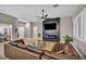 Inviting living room features a cozy leather sectional sofa and a stylish fireplace with mounted TV at 2345 Hot Brook Point St, Las Vegas, NV 89134