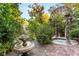 Backyard oasis featuring a stone fountain and a tranquil spa surrounded by lush greenery at 3001 Astoria Pines Cir, Las Vegas, NV 89107