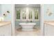 Bright bathroom with a large soaking tub, shuttered windows, and travertine floors at 3001 Astoria Pines Cir, Las Vegas, NV 89107