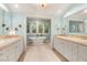 Elegant bathroom featuring dual vanities, a soaking tub, and natural light at 3001 Astoria Pines Cir, Las Vegas, NV 89107