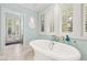 Bright bathroom featuring a standalone tub and large windows providing natural light and outdoor views at 3001 Astoria Pines Cir, Las Vegas, NV 89107
