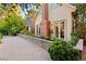 Exterior view of the home featuring a brick chimney, stonework, and manicured landscaping at 3001 Astoria Pines Cir, Las Vegas, NV 89107