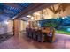 Inviting outdoor patio with a dining table, brick floors, and elegant lighting at 3001 Astoria Pines Cir, Las Vegas, NV 89107