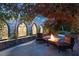 Cozy outdoor patio featuring stone accents, a fire pit, and views of the surrounding greenery at 3001 Astoria Pines Cir, Las Vegas, NV 89107