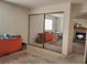 Bright bedroom with mirrored closet doors and view into adjacent living space with fireplace at 3455 Erva St # 219, Las Vegas, NV 89117