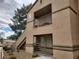 Exterior corner of a stucco building with balconies, staircase, and partial tree cover at 3455 Erva St # 219, Las Vegas, NV 89117