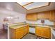 Functional kitchen features wood cabinetry and a connecting breakfast bar with adjacent dining area at 3455 Erva St # 219, Las Vegas, NV 89117