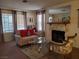 Inviting living room featuring a stone fireplace, plush sofa, and a comfortable armchair at 3455 Erva St # 219, Las Vegas, NV 89117