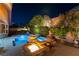 Tranquil backyard featuring a sparkling pool with water features, a cozy fire pit, and serene landscaping at 3459 Ridge Meadow St, Las Vegas, NV 89135