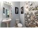 Stylish powder room featuring a pedestal sink, toilet, and decorative art at 3459 Ridge Meadow St, Las Vegas, NV 89135