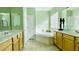 Bright bathroom featuring a soaking tub, double vanity, neutral tile flooring, and decorative accents at 3459 Ridge Meadow St, Las Vegas, NV 89135