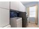 Laundry room with gray washer/dryer, white storage cabinets, and a utility sink at 3459 Ridge Meadow St, Las Vegas, NV 89135