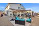Inviting backyard features gravel landscaping, covered patios, seating areas, and an outdoor umbrella for shade at 4050 Peaceful Dune St, Las Vegas, NV 89129