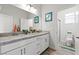 Bathroom with double sinks, granite countertops, and a walk-in shower at 4050 Peaceful Dune St, Las Vegas, NV 89129