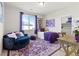 Stylish bedroom with purple accents, soft seating, and ample natural light at 4050 Peaceful Dune St, Las Vegas, NV 89129
