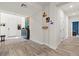 Bright entryway with wood-look floors, decorative console, and coat rack, creating a welcoming entrance to the home at 4050 Peaceful Dune St, Las Vegas, NV 89129