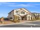 Two-story home with tan stucco, brown tile roof, arched entry, and two-car garage at 4050 Peaceful Dune St, Las Vegas, NV 89129