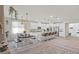 Open kitchen features white cabinetry, granite counters, island with seating, and dining area at 4050 Peaceful Dune St, Las Vegas, NV 89129