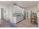 Practical kitchenette with white cabinets, stainless steel appliances, and adjacent laundry area for added convenience at 4050 Peaceful Dune St, Las Vegas, NV 89129