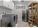 Well-organized laundry room with modern washer and dryer, shelving, and ample storage at 4050 Peaceful Dune St, Las Vegas, NV 89129