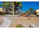 Charming townhomes surrounded by lush trees, rock features, and walkways on a sunny day at 431 Las Casitas Way, Las Vegas, NV 89121