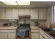 Compact kitchen with essential appliances and white cabinetry under a skylight at 431 Las Casitas Way, Las Vegas, NV 89121