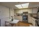 Practical kitchen featuring white cabinets, stainless steel oven, and a skylight at 431 Las Casitas Way, Las Vegas, NV 89121