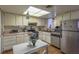 Functional kitchen with white cabinets, stainless steel appliances, and a bright overhead light at 431 Las Casitas Way, Las Vegas, NV 89121