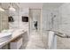 Sleek bathroom with marble tiling, dual vessel sinks, and glass-enclosed shower with multiple shower heads at 4381 W Flamingo # 2201, Las Vegas, NV 89103