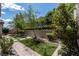 Well-manicured backyard featuring artificial turf, stone accents, and lush landscaping at 441 Beautiful Hill Ct, Las Vegas, NV 89138