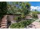Backyard with brick wall, grassy turf, stone steps and mature landscaping at 441 Beautiful Hill Ct, Las Vegas, NV 89138