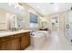Bright bathroom with tiled floor, standalone tub, double vanity with rich wooden cabinets, and glass shower at 441 Beautiful Hill Ct, Las Vegas, NV 89138