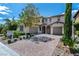 Elegant two-story home with a paver driveway, three-car garage, and lush front yard at 441 Beautiful Hill Ct, Las Vegas, NV 89138
