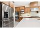 Close-up of a kitchen with stainless steel appliances, custom cabinetry, and a white countertop at 441 Beautiful Hill Ct, Las Vegas, NV 89138