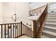 Grand staircase with wood railing and view of open floor plan at 441 Beautiful Hill Ct, Las Vegas, NV 89138
